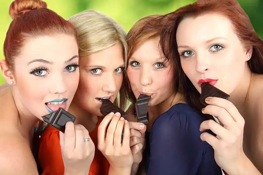 Vier Mädchen essen Schokolade.