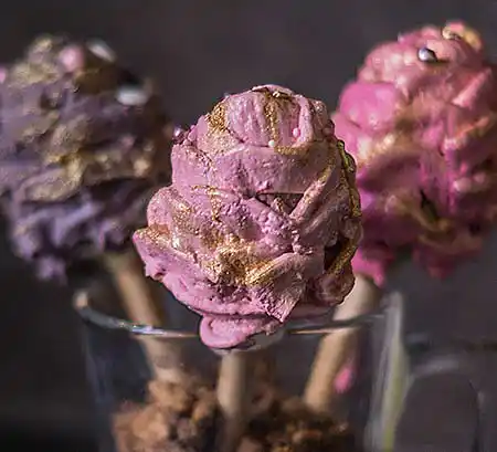 Farbige Cake-Pops in Blütenform im Glas.