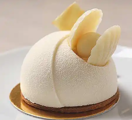 Tisch mit Mousse-Küchlein mit weisser Schokolade.