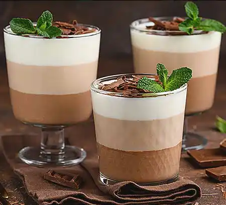 Gläser mit Schokomousse mit dreierlei Schokoladen, Minze und Schokstreusel.