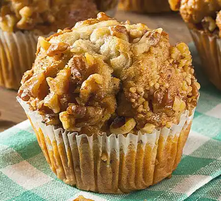 Bananen-Nuss-Crunch-Muffin auf grüner Tischdecke.