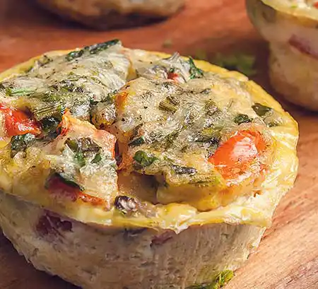Eier-Muffin mit Gemüse auf Holztisch.