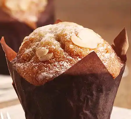 Mandel-Muffin in Papier gewickelt.