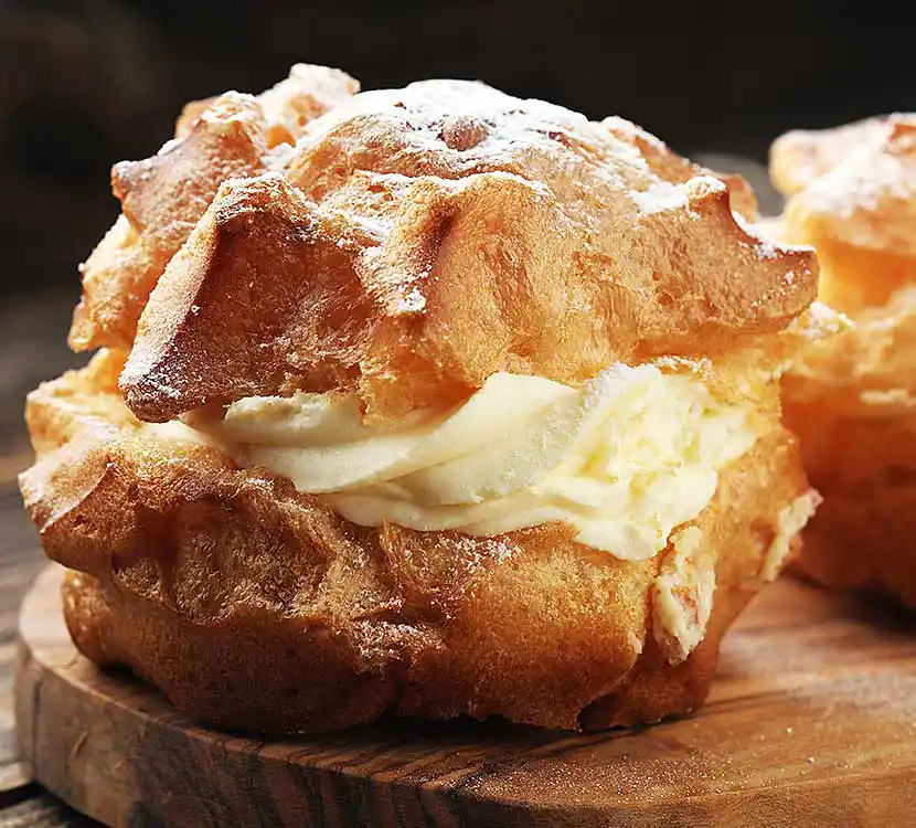 Holzbrett mit Windbeutel.