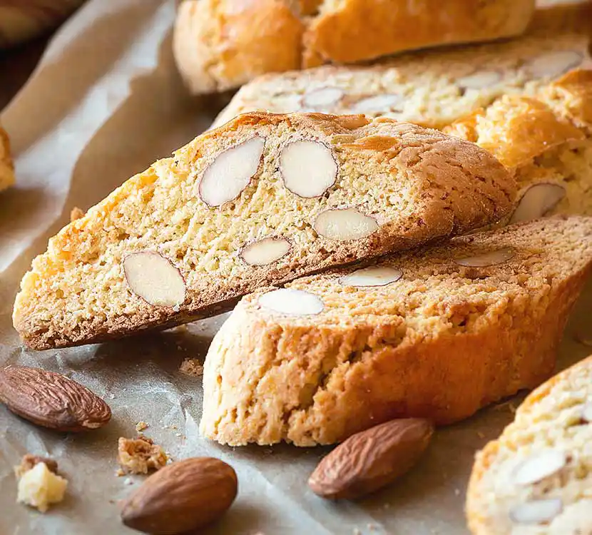 Tisch mit italienischem Mürbegebäck und Mandeln als Deko.