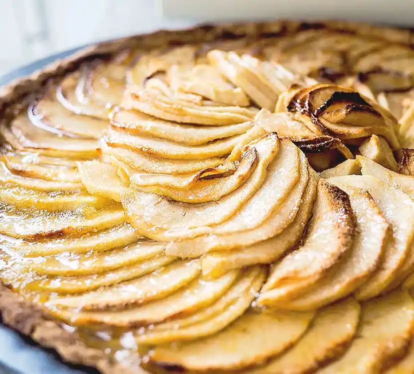 Ganzer Kuchen mit Apfelstücken.