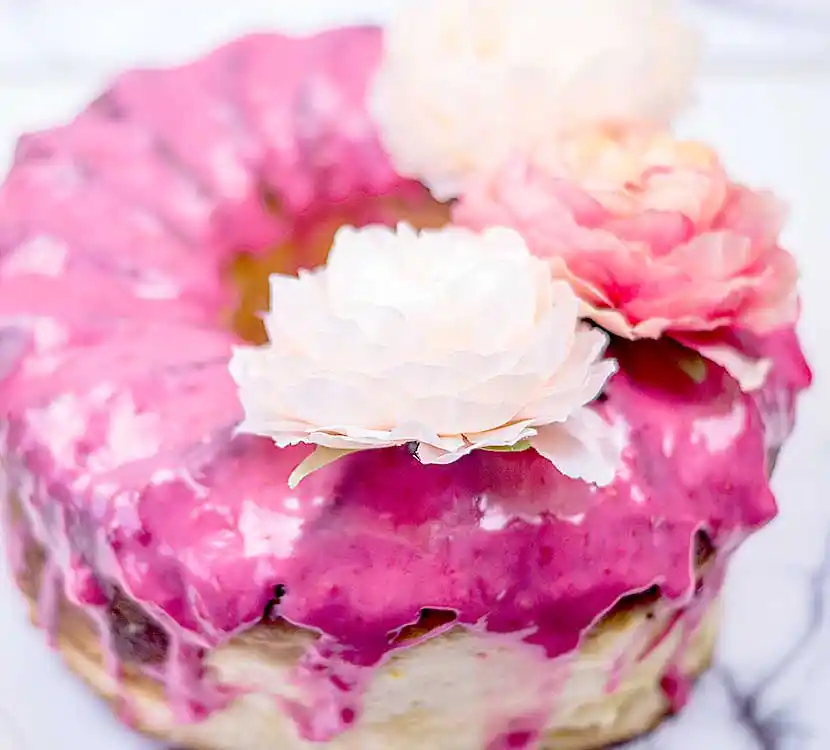 Kuchen mit Himbeerfarbenem Zuckeguss und Rosendekor.