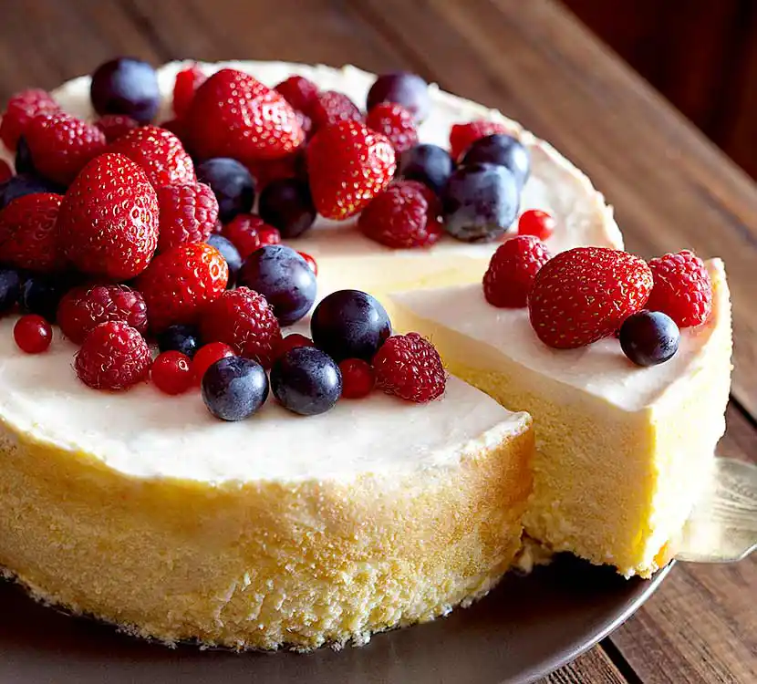 Tablett mit angeschnittener Mascarpone-Creme-Chesscake mit saisonalen Früchten.