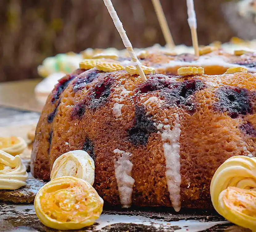 Tisch mit Buttermilch-Blaubeer-Kuchen im Boho-Stil.