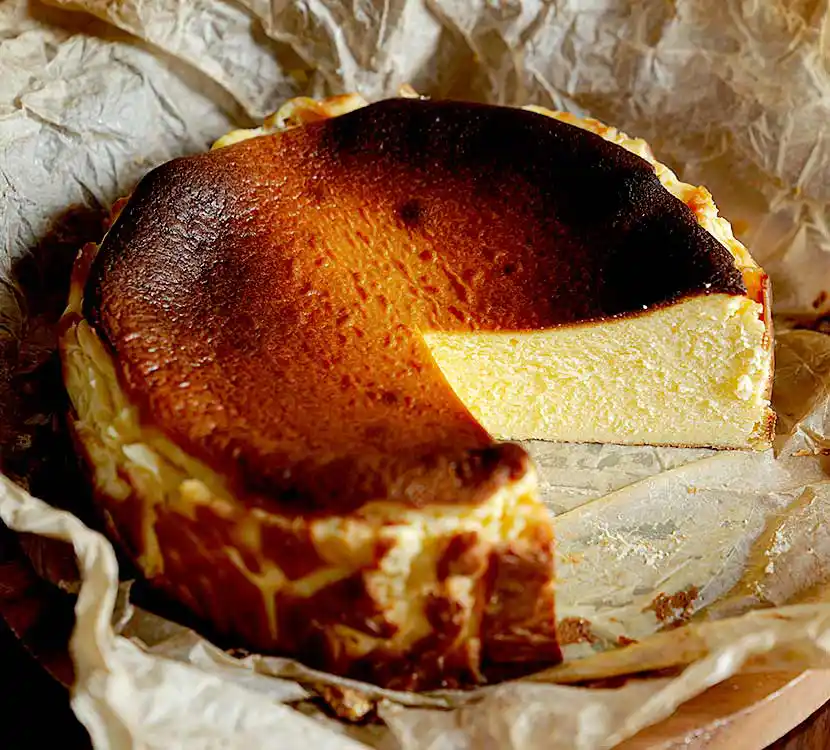 Auf Papier liegender gebrannter Quarkkuchen.