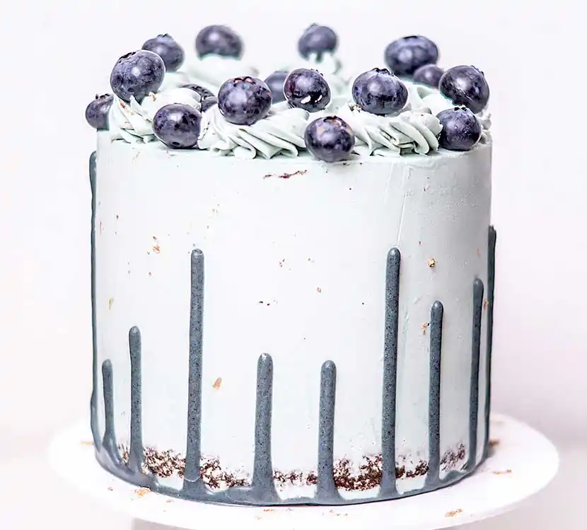Weiße Torte mit Upside Down Drip und Blaubeerendekor.