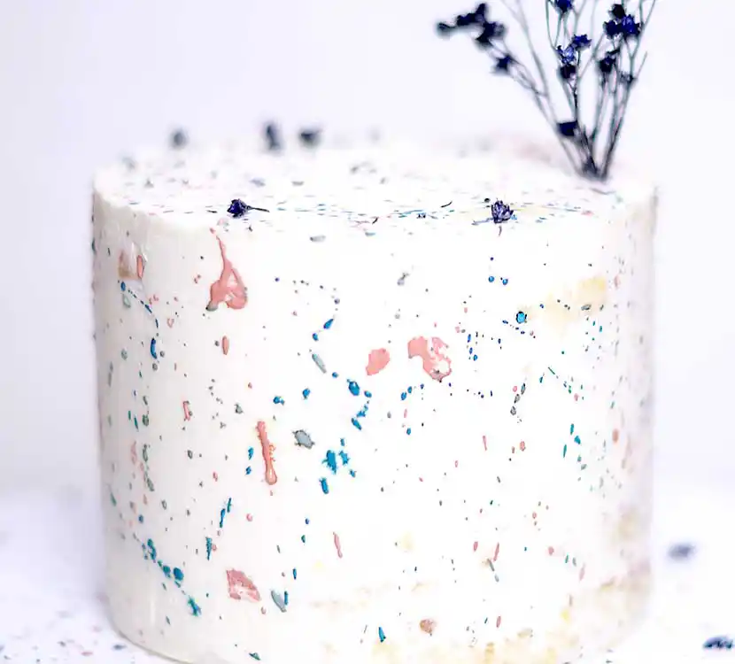 Teller mit weißer, Torte, farbig gesprenkelt.