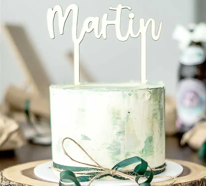 Teller mit weiß-grüner Torte und Namenstopping.