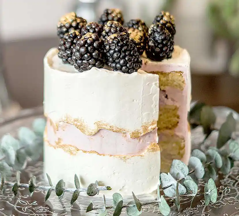 Teller mit angeschnittener Torte im Fault-Line-Dekor mit Brombeeren.