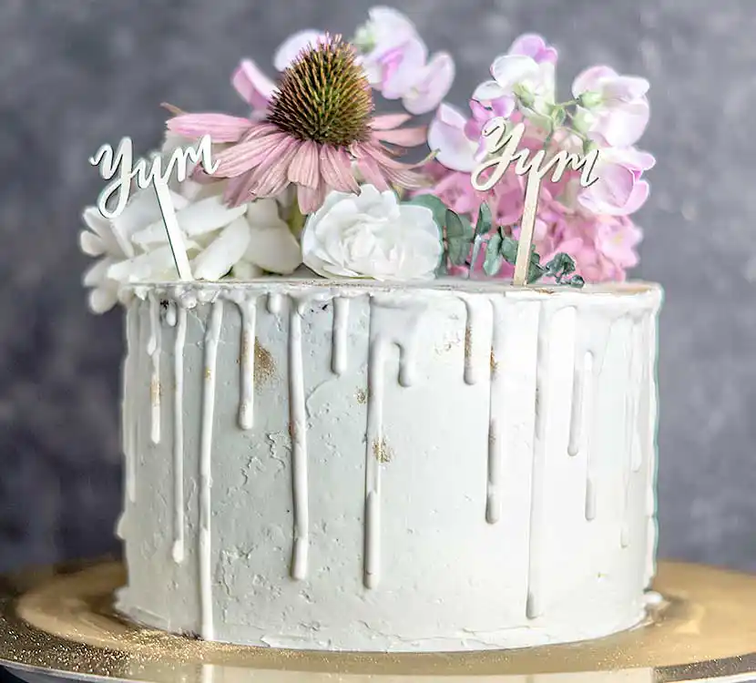 Mit Buttercreme eingestrichene Torte mit Blumendekor.