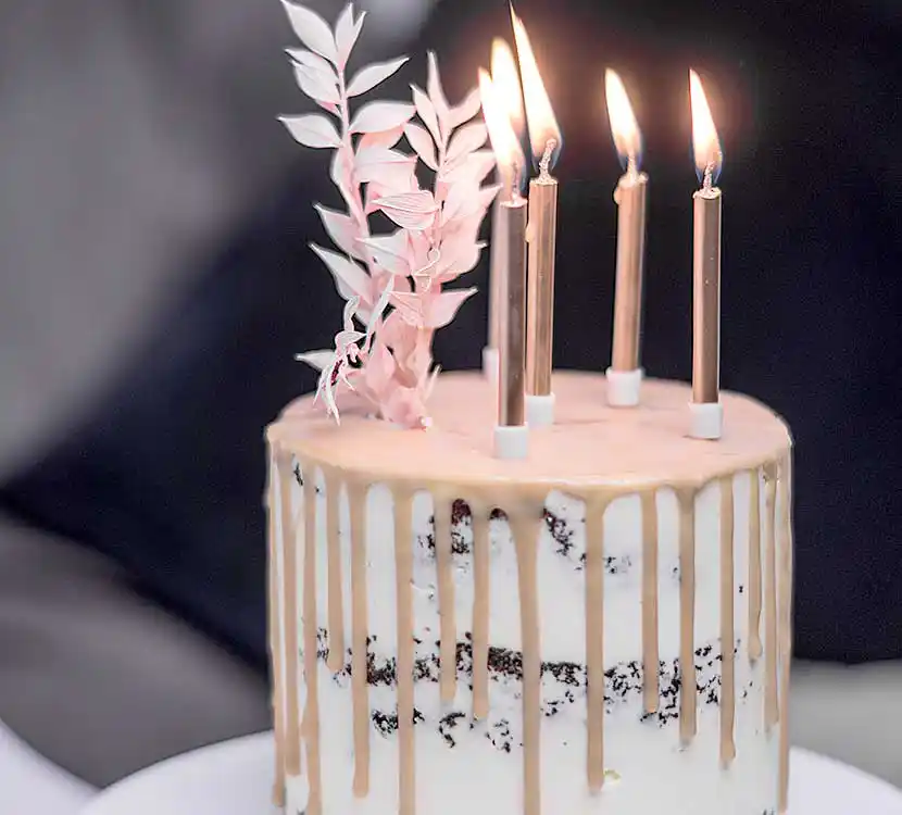 Weiße Torte mit Schoko-Drip und Kerzendeko.