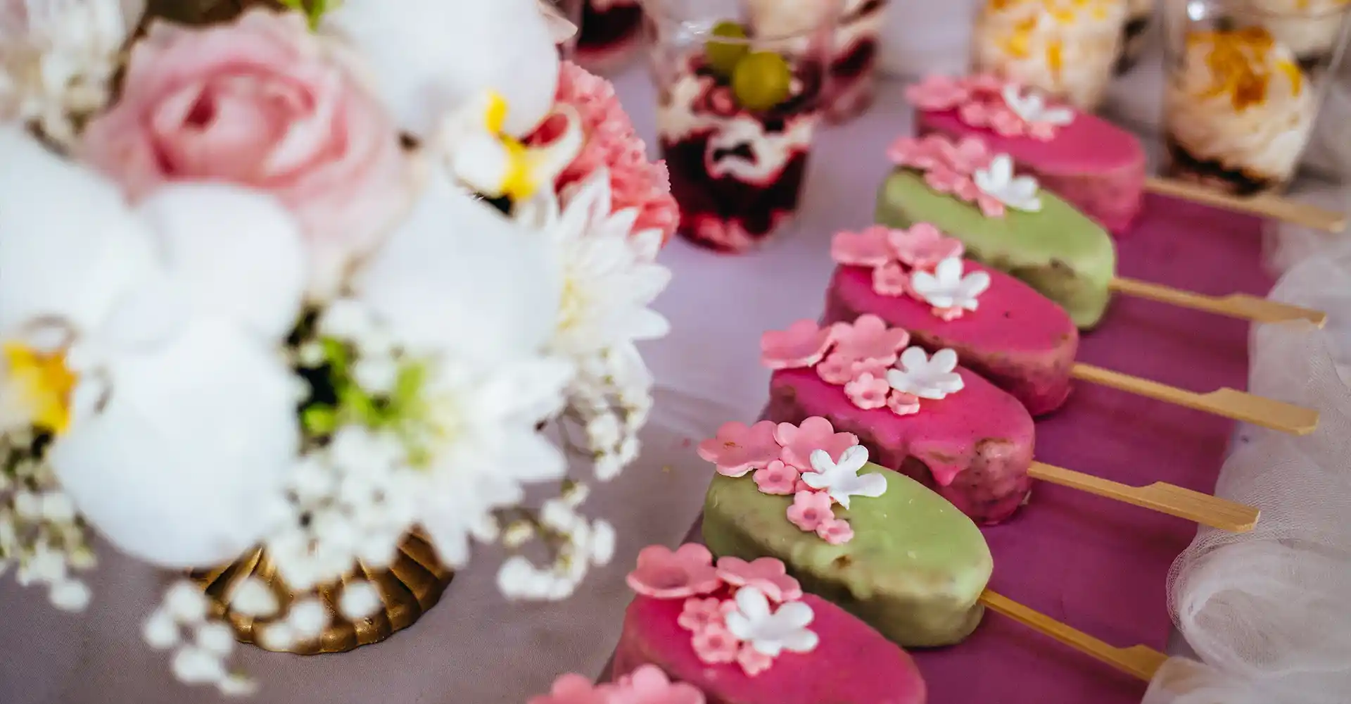 Still mit Cake Pop auf dunklem Tisch mit Holunderblüten.