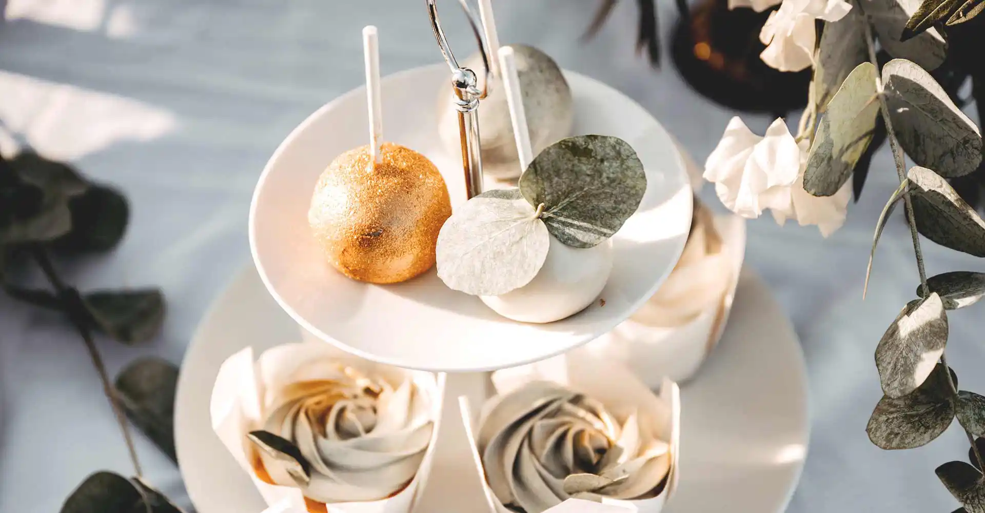 Dekorierter Tisch Etagerer und 2 Cakepops in Gold und Weiß.